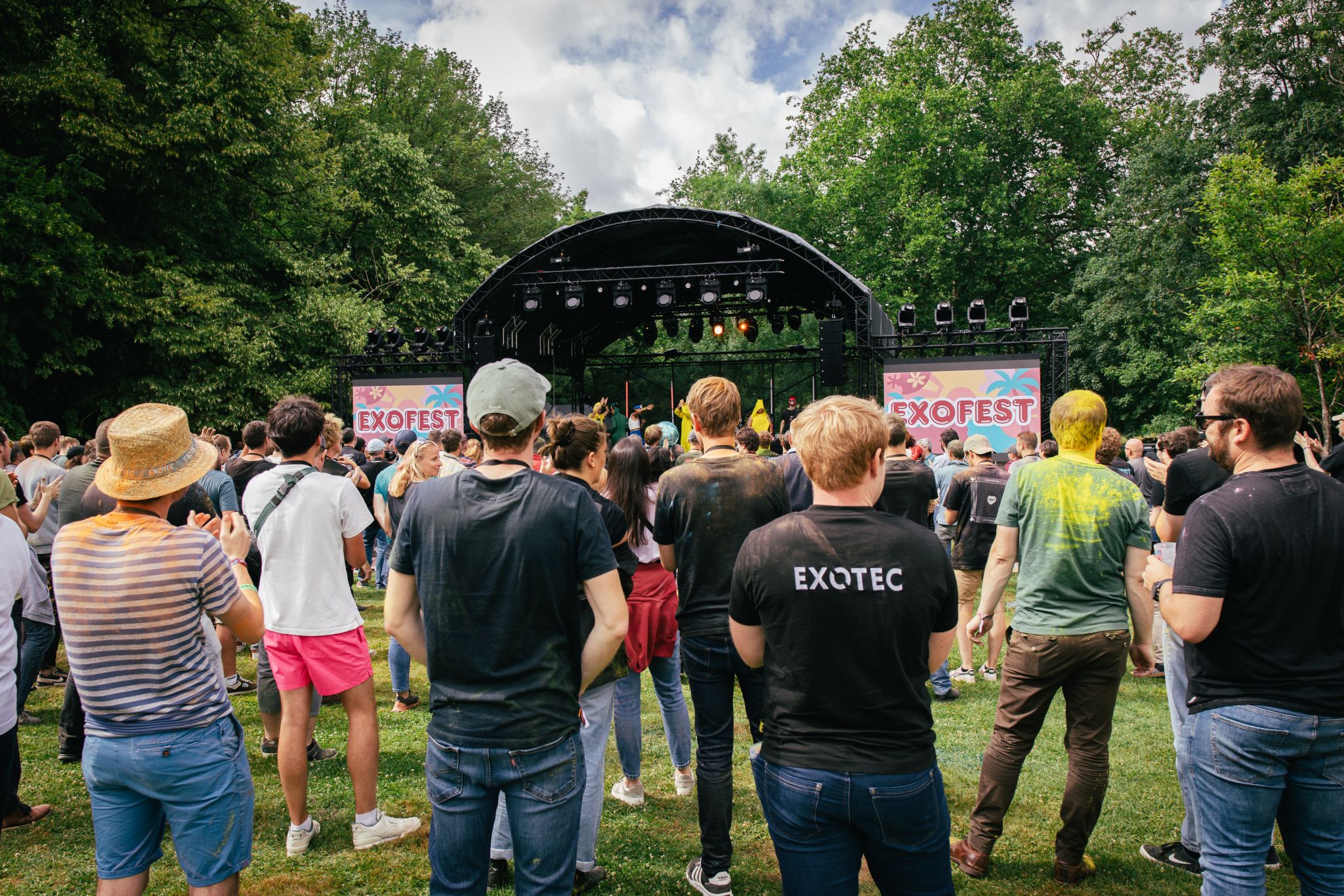 Public réuni devant une scène lors d’un festival d’entreprise en plein air