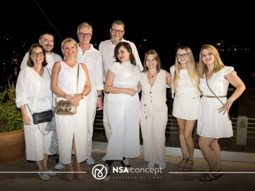 Soirée blanche Groupe de collaborateurs posant ensemble lors d’une soirée d’entreprise en tenue blanche